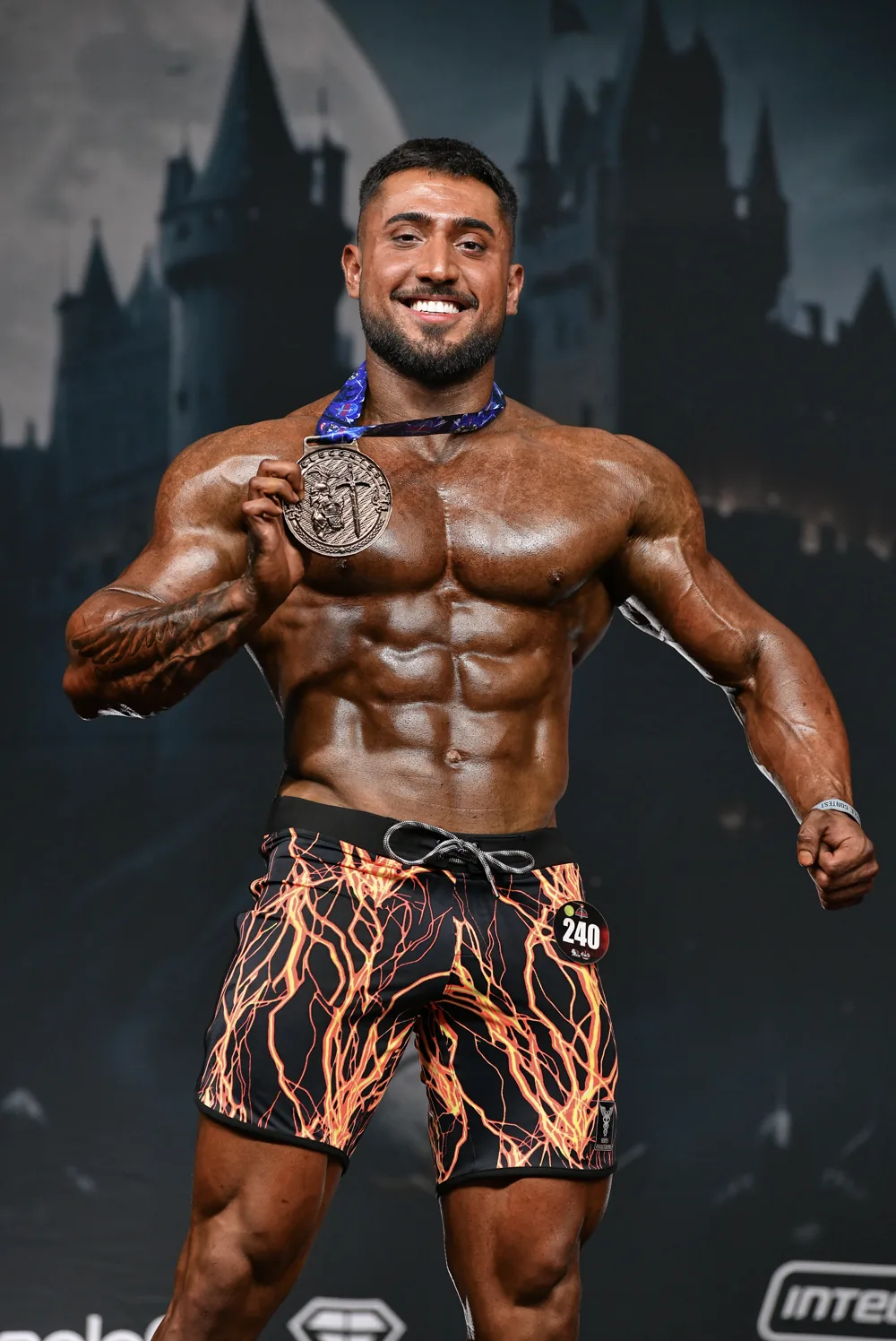 Davi Frois no palco de fisiculturismo exibindo sua medalha